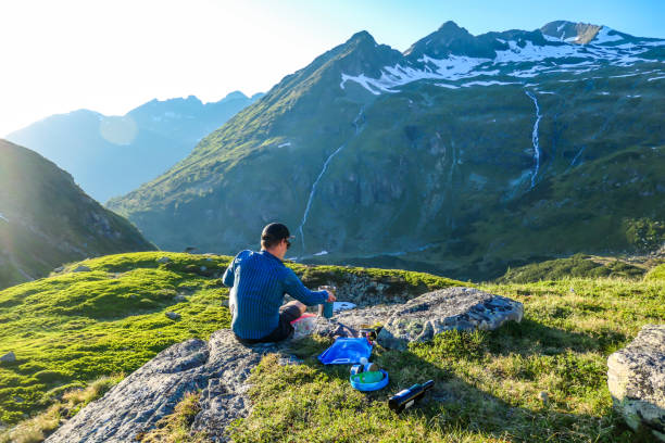 istock Schladming - Man cooking dinner in the wilderness during the sunset 1186133935