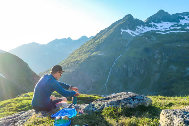 istock Schladming - Man cooking dinner in the wilderness during the sunset 1186133962