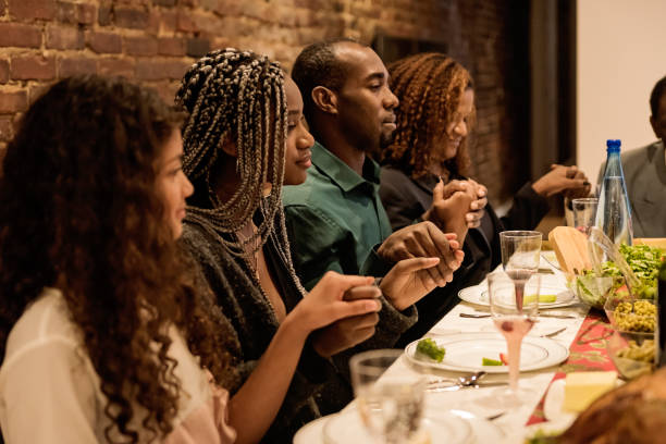 famiglia multigenerazionale che dice grazia per la cena del ringraziamento. - family american culture african culture black foto e immagini stock