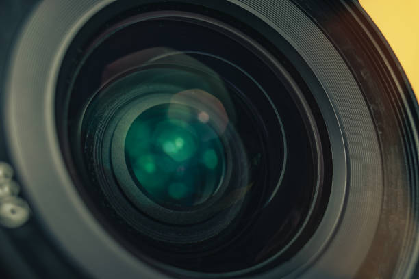 istock Close up beautiful black camera lens on a yellow background. Macro view.. 1186136497
