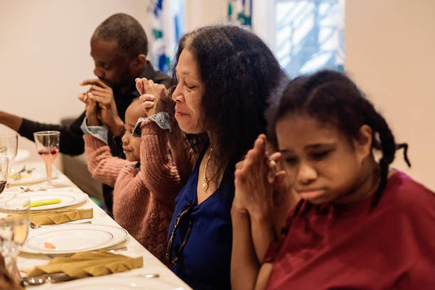 istock Multi-generation family saying grace for Thanksgiving dinner. 1186136567