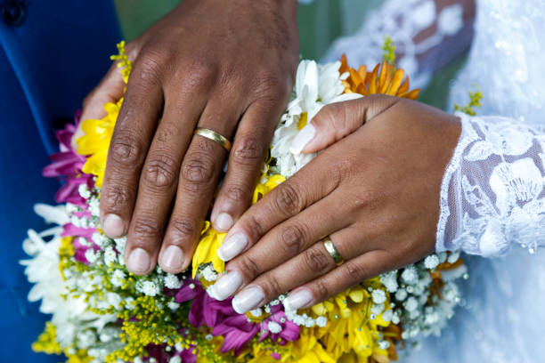 mains unies et anneaux de mariage - color image gold yellow black photos et images de collection