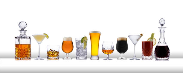 een lijn van aclcoholic dranken van whisky tot pils, in een lijn, op een witte balk als oppervlak - alcohol drinks stockfoto's en -beelden