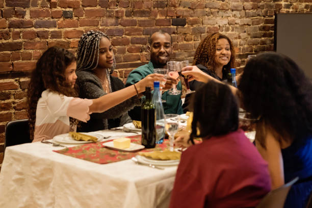 istock Family cheering enjoying Thanksgiving dinner. 1186139601