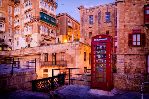 Red phone box over Victoria Gate bridge in Valletta old town, Malta