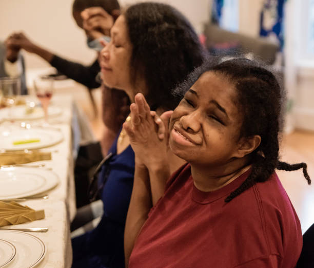 istock Disable women saying grace for Thanksgiving dinner. 1186140483