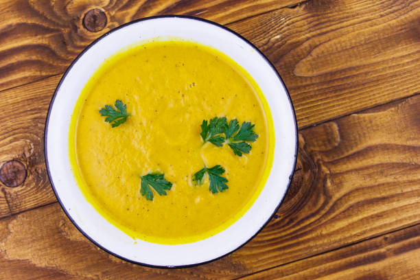 istock Pumpkin soup on a wooden table. Top view 1186140723