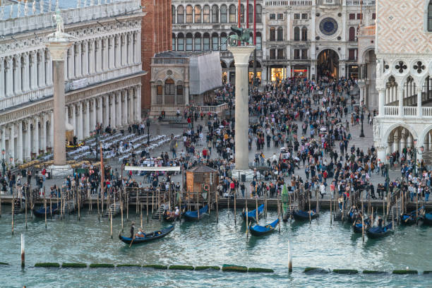 Venice, Italy - October 11, 2019: Autumn sunset view from cruise ship towards the masses of tourists and gondolas at the lagoon near San Marco Square