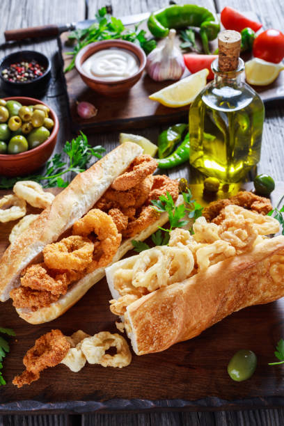 sandwiches with calamari rings, bocadillos de calamares, fresh bread roll filled with squid rings that have been coated in flour - verticak imagens e fotografias de stock