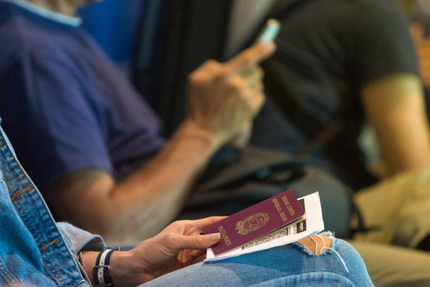 女子拿著護照和登機牌在機場大廳等候航班 - 意大利語 個照片及圖片檔