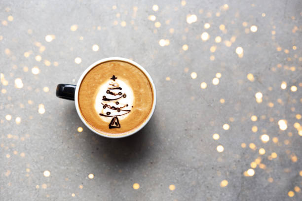 Tasty cappuccino with Christmas tree latte art Tasty cappuccino with Christmas tree latte art with some blurred lights on grey concrete background. Holiday concept. winter food top view stock pictures, royalty-free photos & images