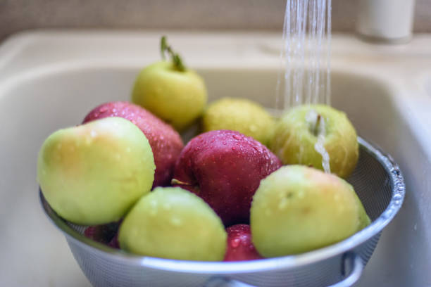 enrreciendo manzanas frescas en el fregadero - drop red delicious apple apple fruit fotografías e imágenes de stock