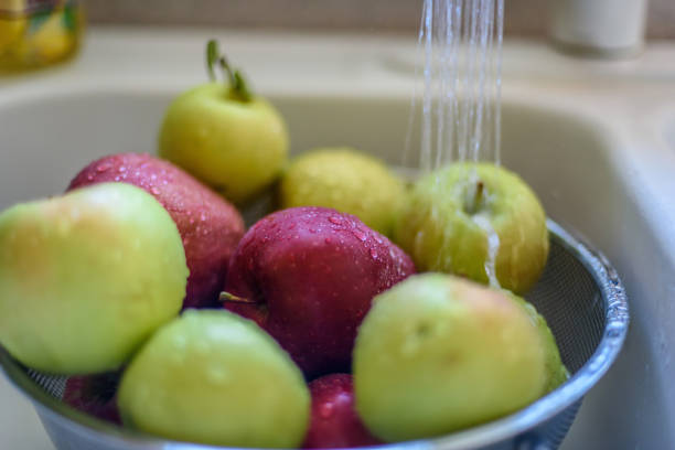 부엌 싱크대에서 신선한 사과를 헹다 - drop red delicious apple apple fruit 뉴스 사진 이미지