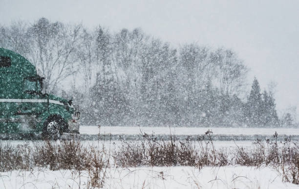 Semi truck driving in heavy snow.
