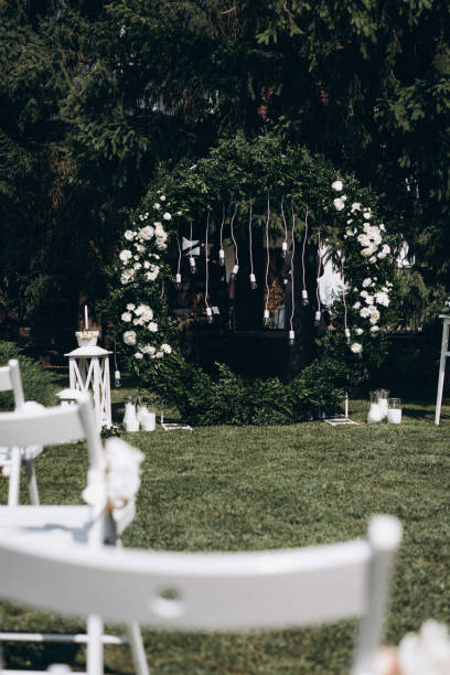 une place pour les invités à une cérémonie de mariage, chaises blanches décorées de fleurs. décorations de mariage. mise au point sélective, film et photo de grain - just married concepts ideas place setting photos et images de collection