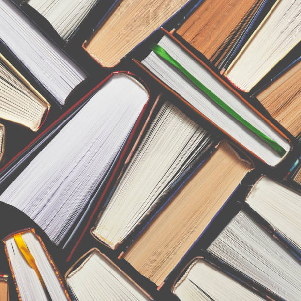 istock Lots of colourful thick open books stand on a dark background 1186145833
