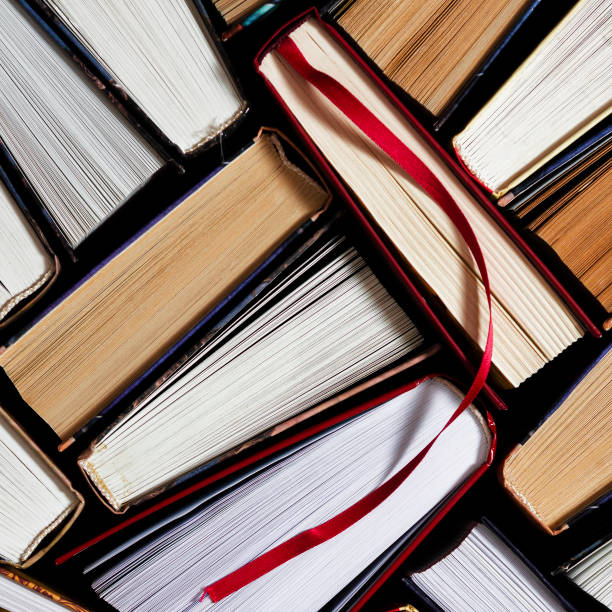 istock Lots of colourful thick open books stand on a dark background 1186145834