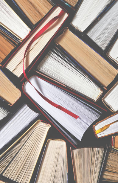 istock Lots of colourful thick open books stand on a dark background 1186145836