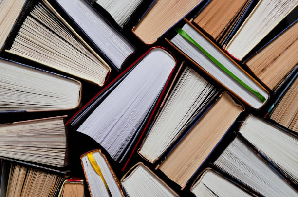 istock Lots of colourful thick open books stand on a dark background 1186145844