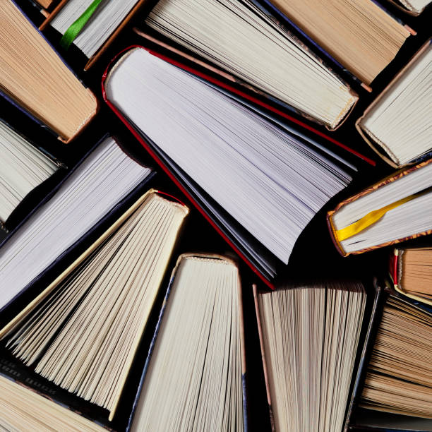 istock Lots of colourful thick open books stand on a dark background 1186145847