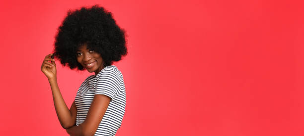Beautiful afro american girl isolated on red background.