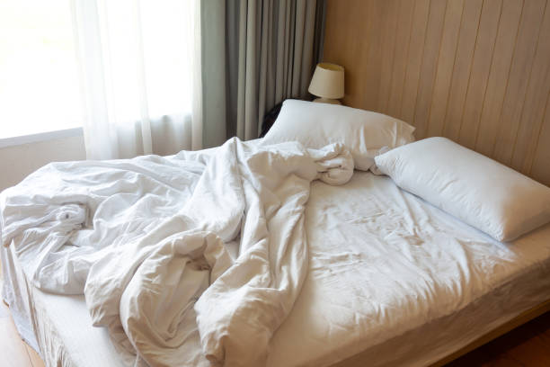 istock Messy bed. Couple pillows with white blanket on unmade  bed. 1186150422