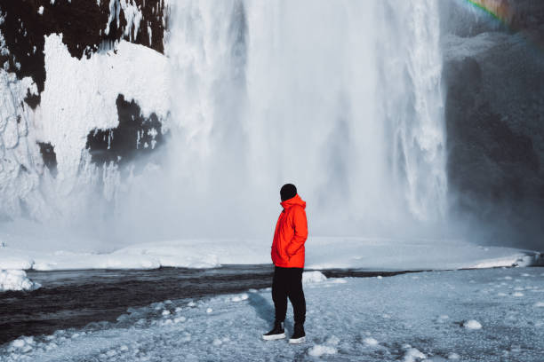 istock Man meets winter under Skogafoss waterfall in Iceland 1186152956