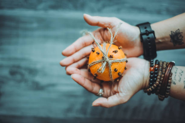 Asian chinese female holding Orange Clove Pomander on her hand as a gift stock photo