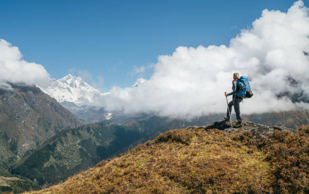 istock Young hiker backpacker man using trekking poles enjoying the Nuptse 7861m mountain during high altitude Acclimatization walk. Everest Base Camp trekking route, Nepal. Active vacations concept image 1186157643