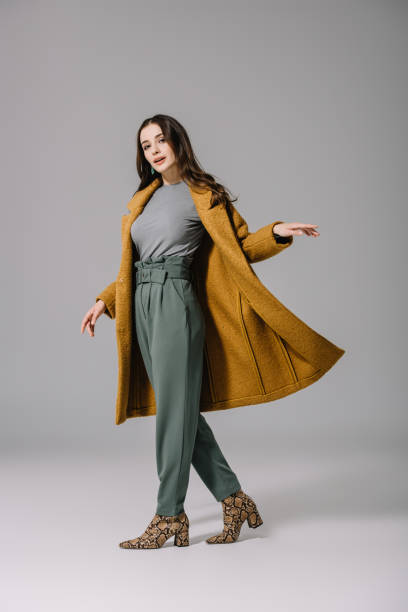 회색에 베이지 색 가을 코트에 포즈를 취하는 우아한 여자 - studio model 뉴스 사진 이미지