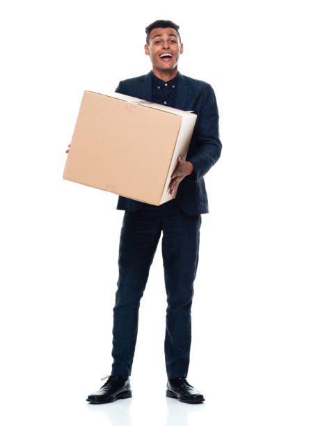Full length / front view / one man only / one person of 20-29 years old adult handsome people black hair / short hair african ethnicity / african-american ethnicity male / young men businessman / business person standing wearing businesswear / business casual / smart casual / button down shirt / shirt / a suit who is smiling / happy / cheerful / laughing who is moving office and holding cardboard box / cardboard / box - container / package / container longitud completa / vista frontal / un hombre solamente / una persona de 20-29 años adulto saciedad personas hermosas pelo negro / pelo corto etnia africana / etnia afroamericana hombre / hombres jóvenes hombre de negocios / persona de negocios de pie co