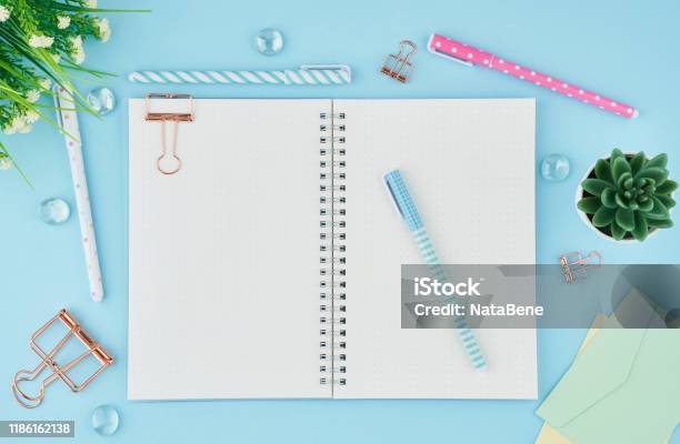 Blank Notepad Page In Bullet Journal On Bright Blue Office Desktop Top View Of Modern Table With Notebook Stationery Mock Up Copy Space Concept For Diary Stock Photo - Download Image Now