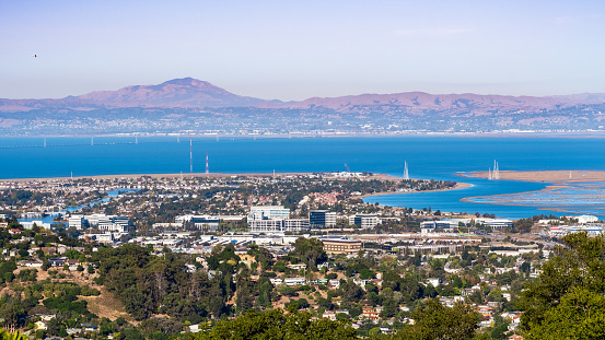 Aerial view of San Carlos and Redwood Shores; East Bay and Mount Diablo in the background; houses visible on the hills and close to the shoreline; office buildings built close to downtown San Carlos