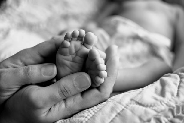 istock Mother Holds Infants Feet 1186167922