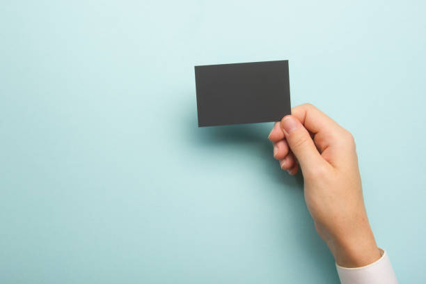 istock Hand holding white business card on white background 1186168299