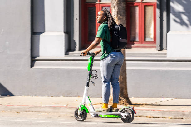 Young man riding a lime scooter in downtown San Francisco Nov 2, 2019 San Francisco / CA / USA - Young man riding a lime scooter in downtown San Francisco; Lime is the brand name under which Neutron Holdings, Inc. operates a fleet of electric scooters lime scooter stock pictures, royalty-free photos & images