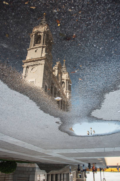 Reflection of Almudena Cathedral in a water puddle. Madrid, Spain