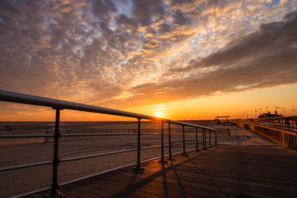 istock Boardwalk ramp leading down to a beach under golden sunlight from a beautiful sunset. 1186169417