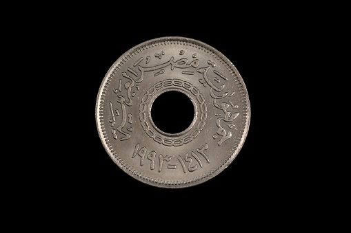 An old Israeli one shekel coin, shot close up in macro, against a black background