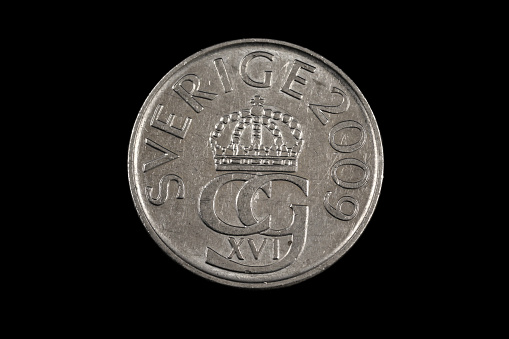 A close up, macro image of an old Swedish five krone coin isolated on a black background