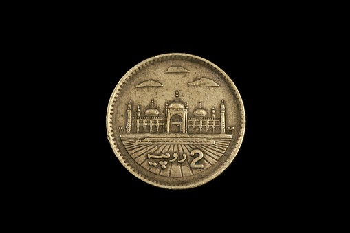 A macro image of an two rupee coin from Pakistan, shot close up, against a black background