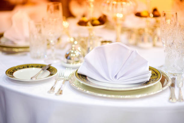 Beautiful table setting with crockery and flowers for a party, wedding reception or other festive event. Glassware and cutlery for catered event dinner.