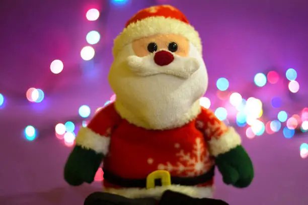 A Santa Claus puppet is sitting, with a beautiful bokeh that is visible in the background.