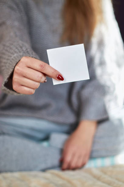 istock Woman hand with red manicure holding white blank 1186180472