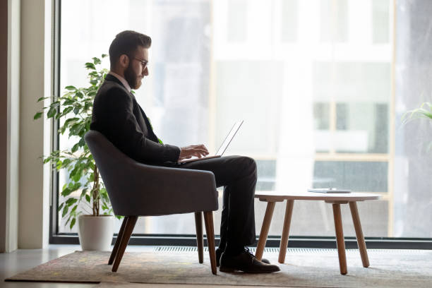 istock Arab businessman sitting in office lobby working on laptop 1186185198