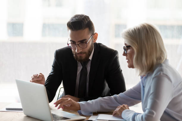 istock Aged mentor explain corporate app to middle eastern ethnicity employee 1186185205