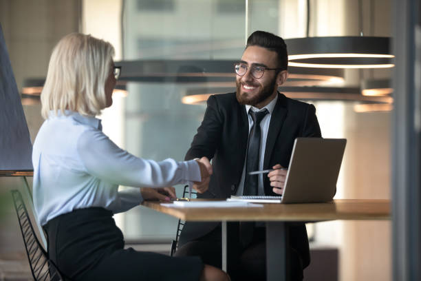 middle eastern ethnicity hr manager assunzione di anziani donna stretta di mano - middle eastern ethnicity business greeting handshake foto e immagini stock