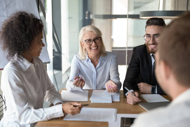 istock Multi-ethnic smiling office workers chatting at briefing in boardroom 1186185263