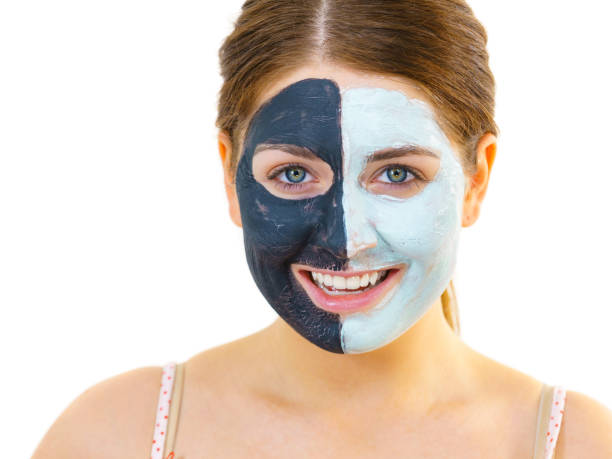 istock Girl with black white mud mask on face 1186185958