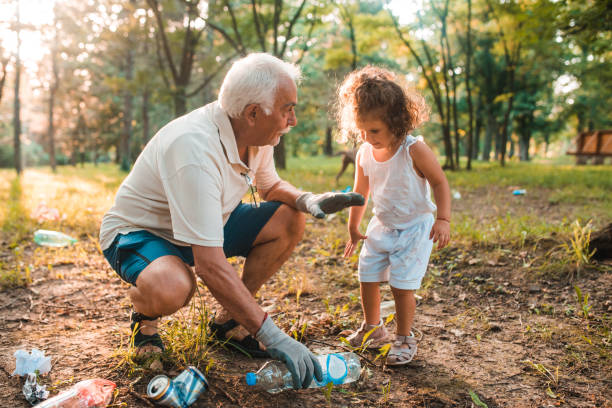 grandpa teaching his granddaughter to keep the environment clean - sustainable resources environment education cleaning imagens e fotografias de stock